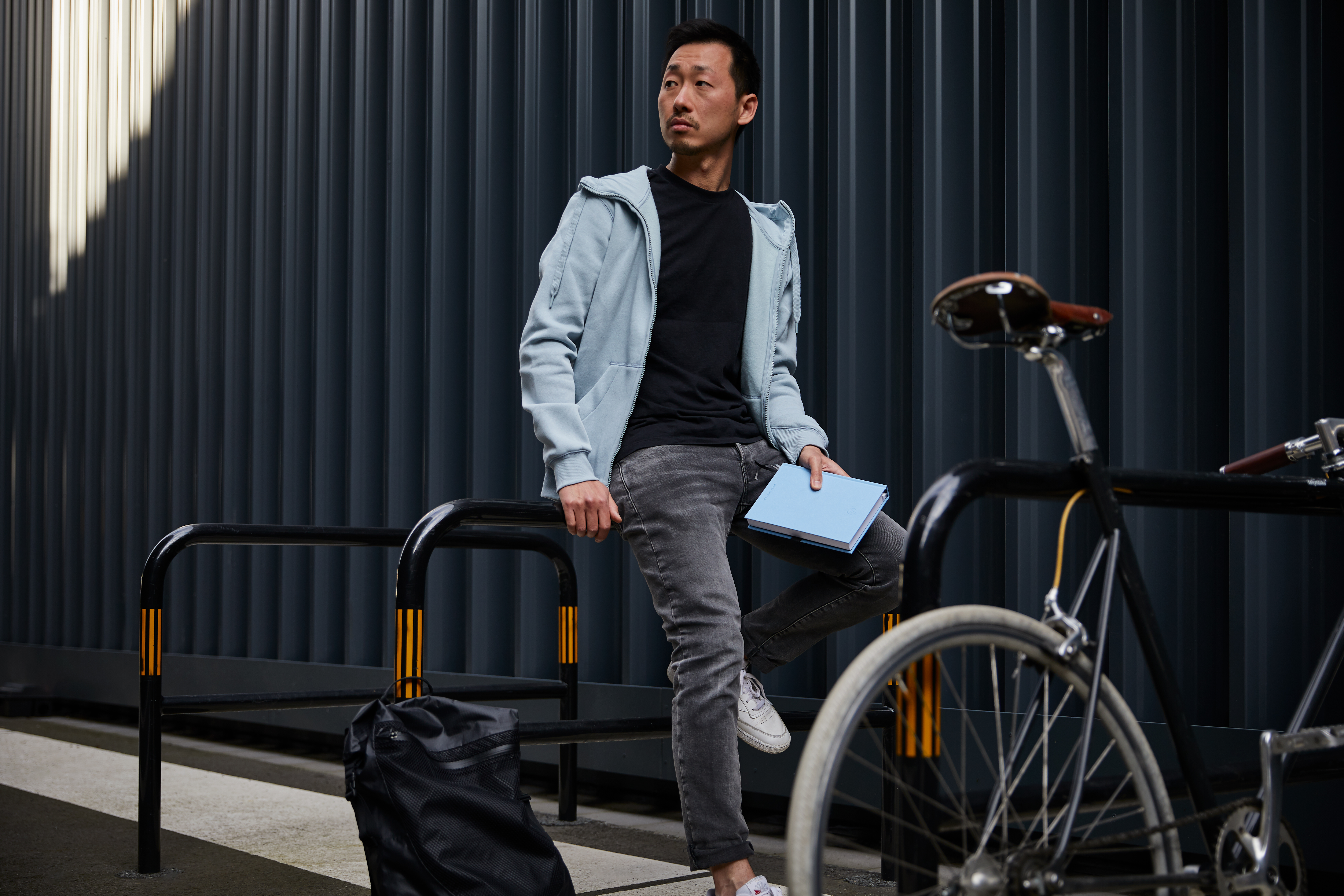 Mann sitzt auf eines Fahrrad Bügel mit Buch in der Hand